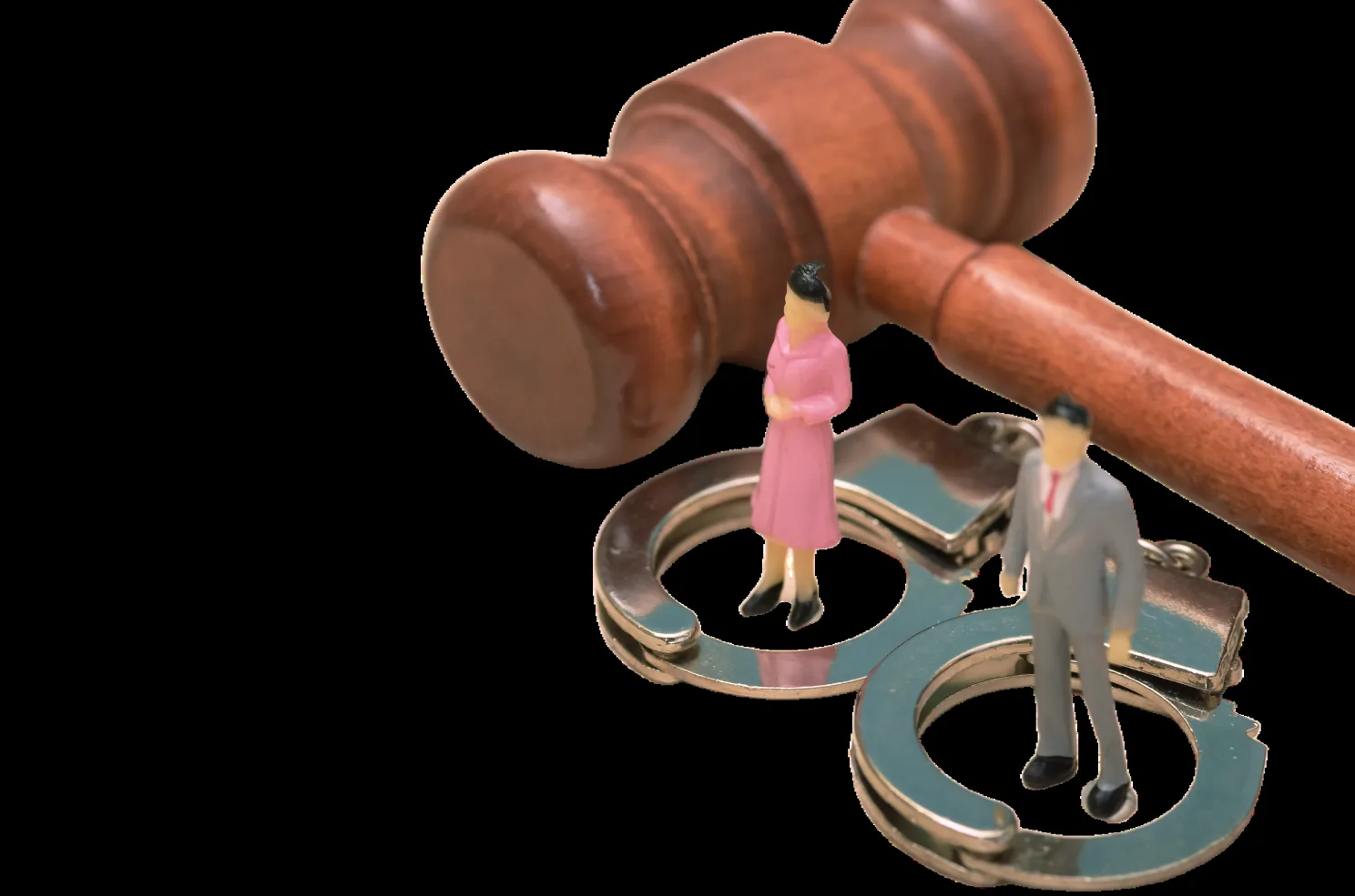 Gavel above two handcuffs, with two small figures placed inside the rings.